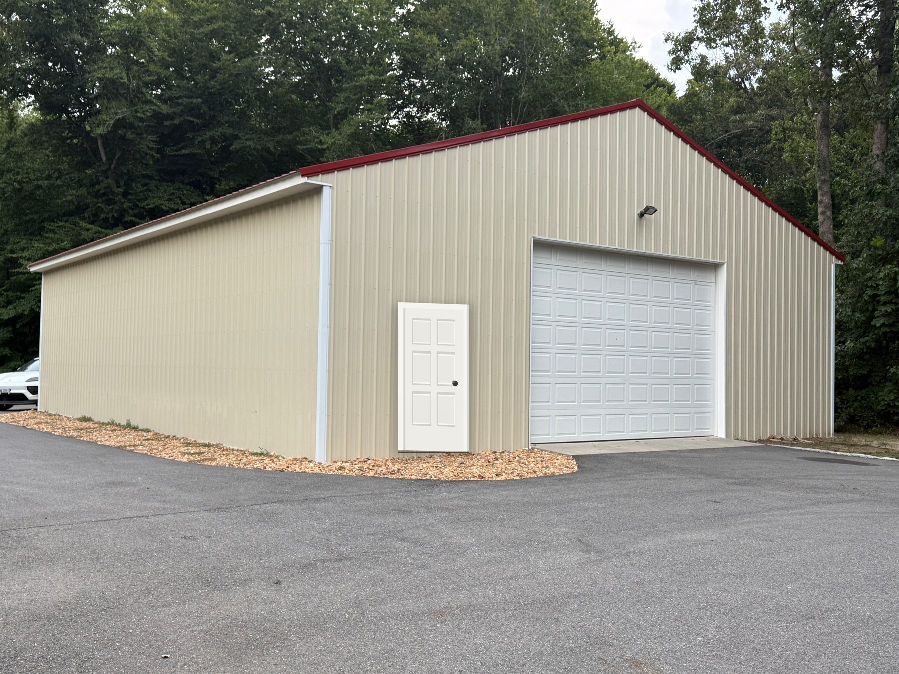 Photo concept: the barn's gable end with a new white entry door added to the left of the garage door